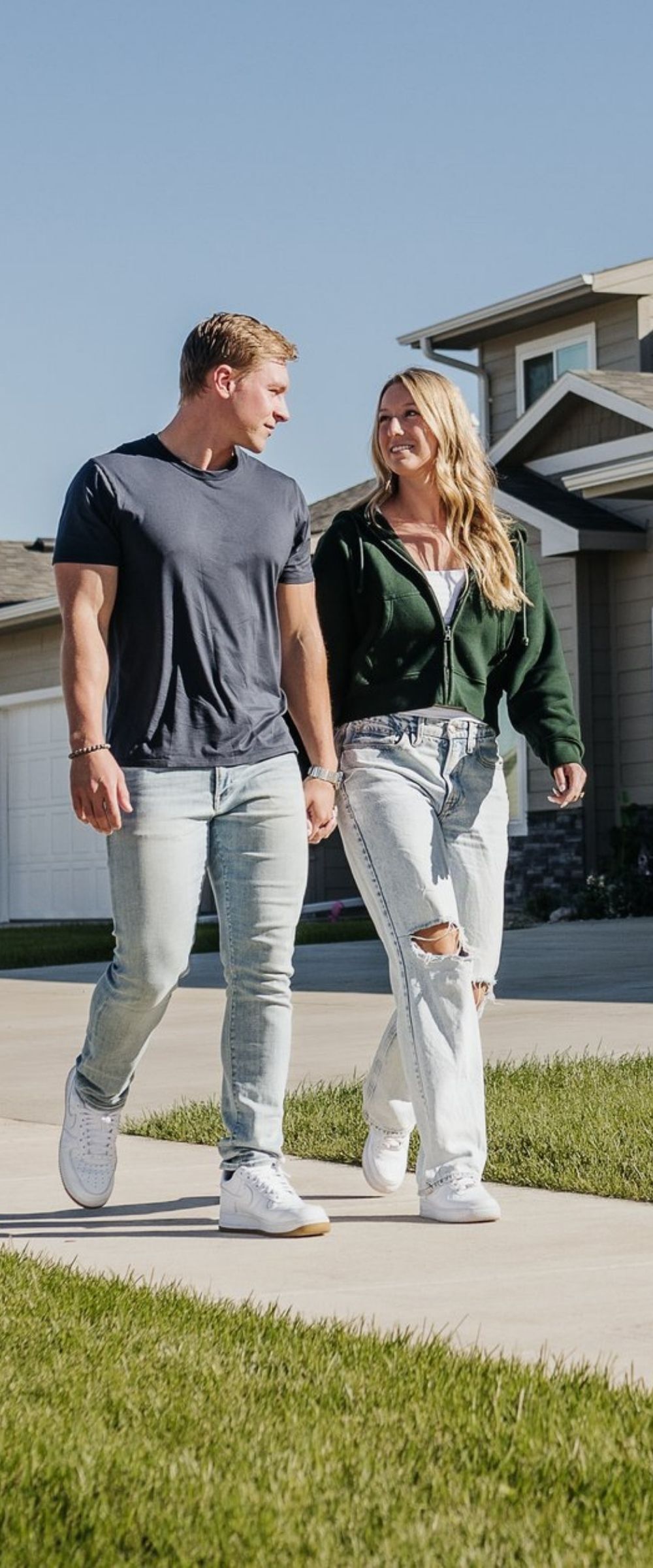 A couple walking hand in hand down the sidewalk of a new Empire Homes neighborhood in Sioux Falls