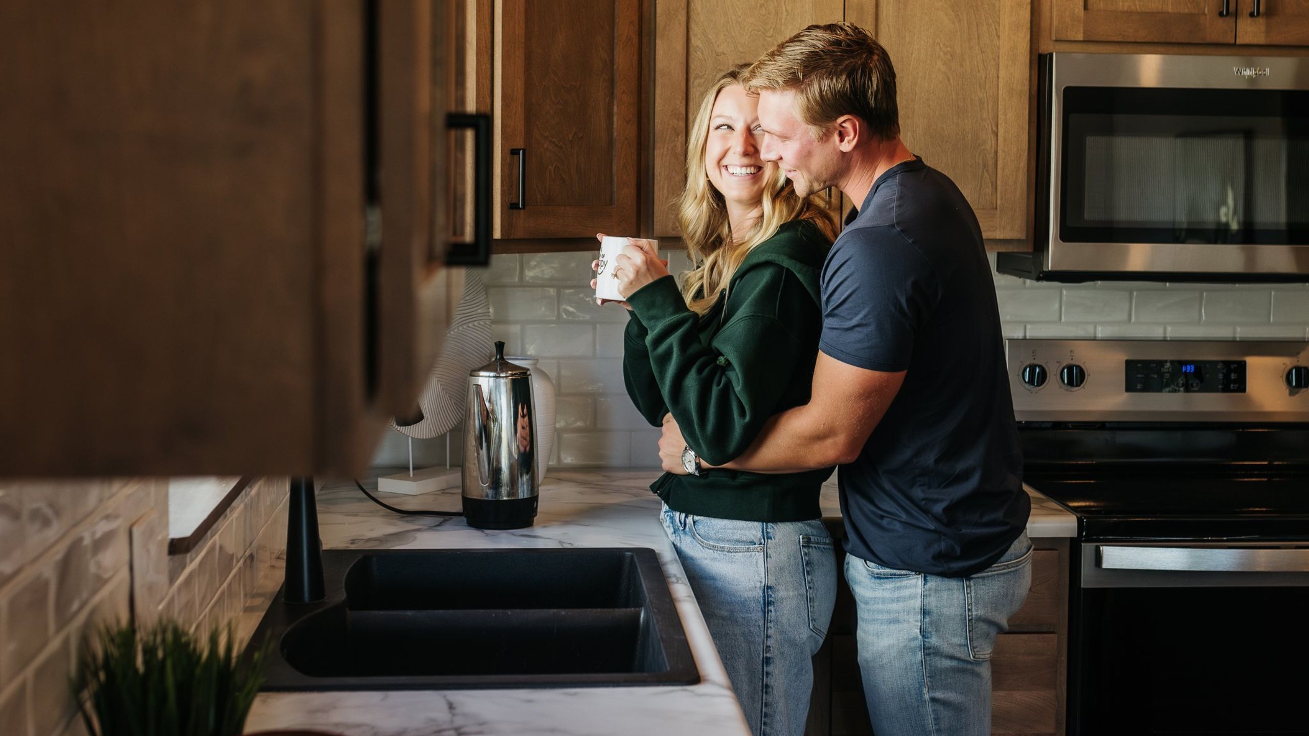 A smiling couple sharing a morning coffee in the kitchen of their new Empire Home in Sioux Falls